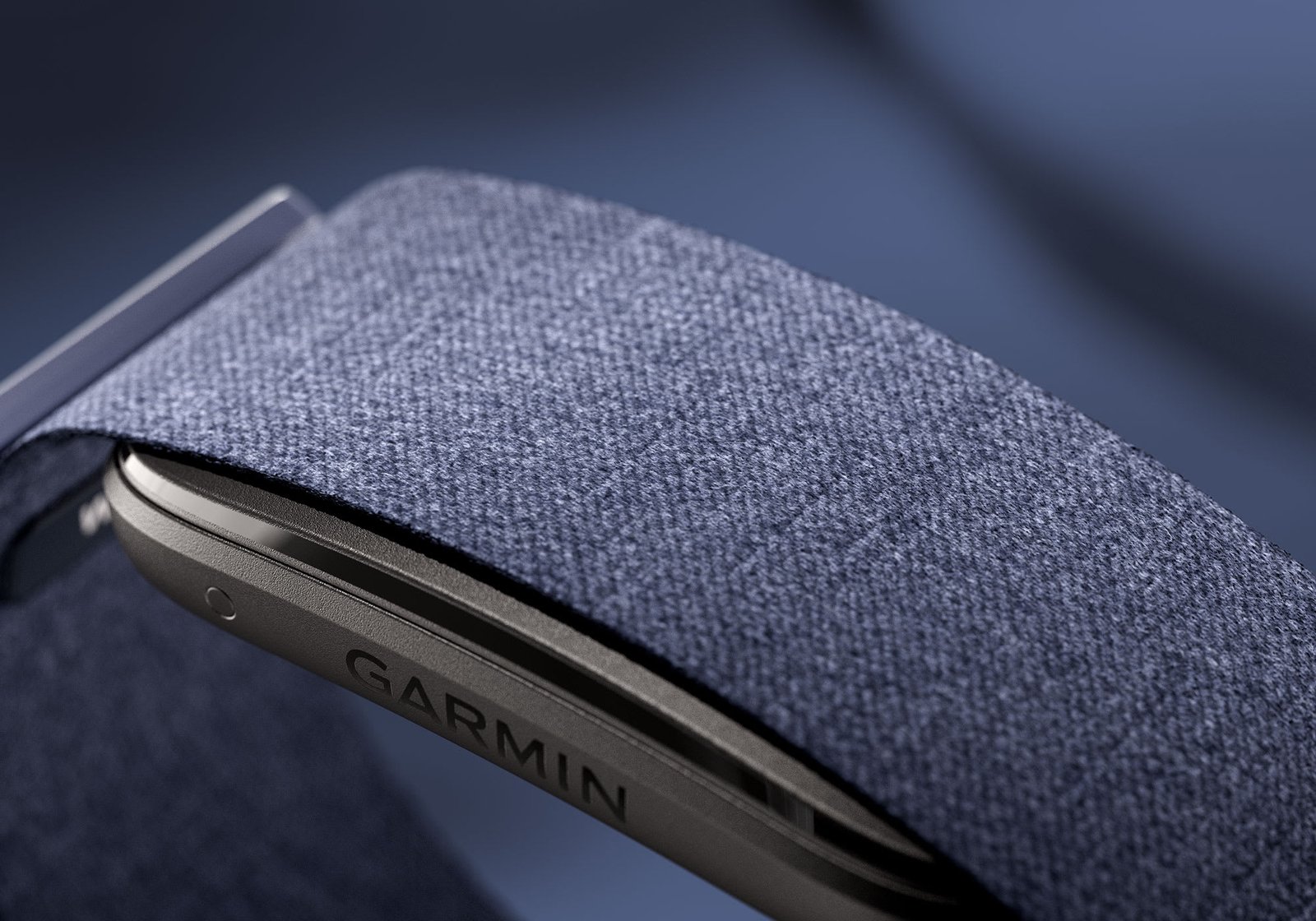 Detalle macro de la banda de tela de CIRQA Smart Band, color azul marino, con el logo Garmin grabado